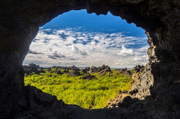 Guardando il paesaggio attraverso il foro di una grotta nel myvatn, islanda