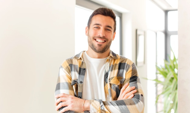 looking like a happy, proud and satisfied achiever smiling with arms crossed