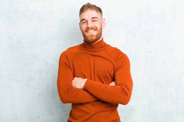 looking like a happy, proud and satisfied achiever smiling with arms crossed