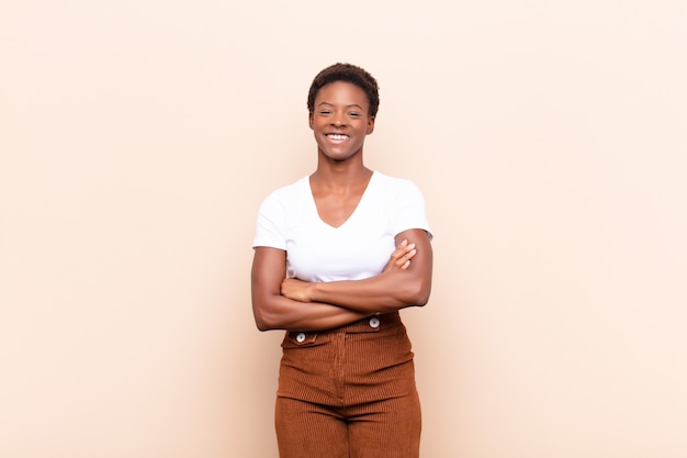 looking like a happy, proud and satisfied achiever smiling with arms crossed