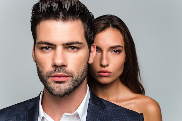 Looking at one side together Portrait of young beautiful couple looking at camera while standing against white background