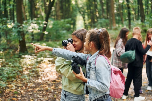 Foto alla ricerca di un percorso bambini nella foresta verde durante il giorno d'estate insieme