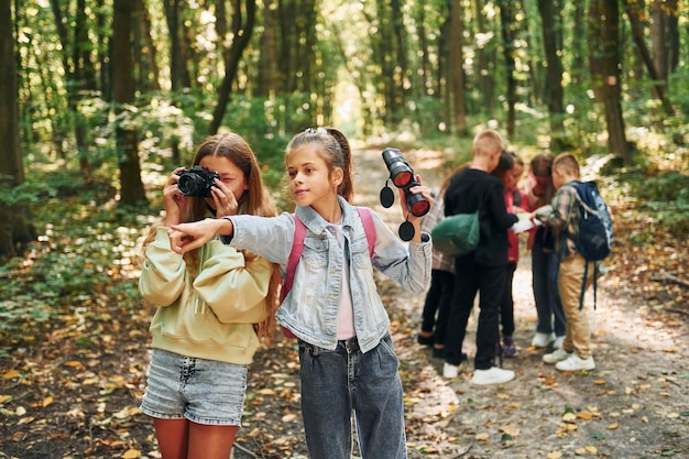 Photo looking for a path kids in green forest at summer daytime together