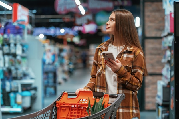 商品を探している 女性がスーパーマーケットで買い物をしています