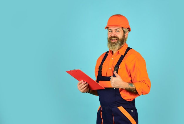 Looking project folder blueprint in folder making notes in clipboard portrait of engineering man construction worker holding folder Structural plan safety work operation concept copy space