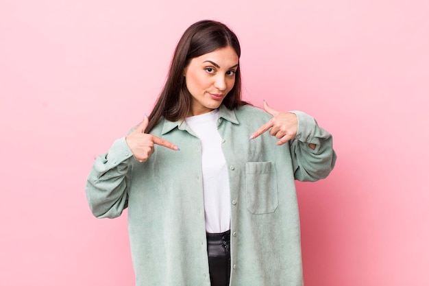 Looking proud positive and casual pointing to chest with both hands