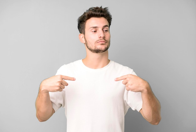 Looking proud positive and casual pointing to chest with both hands