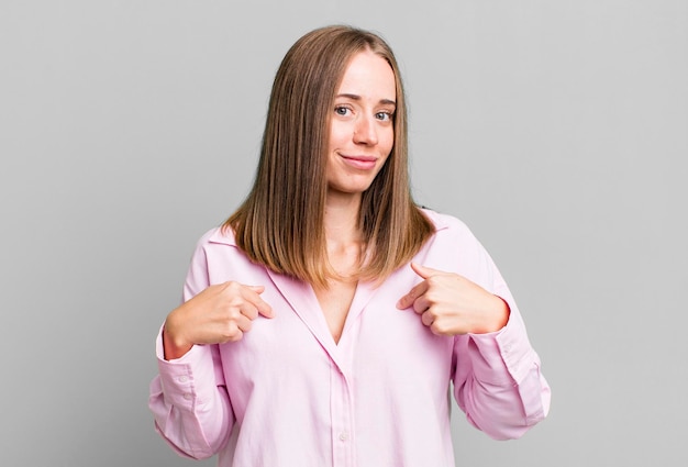 Looking proud positive and casual pointing to chest with both hands