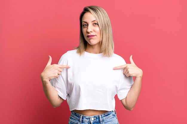 Looking proud positive and casual pointing to chest with both hands