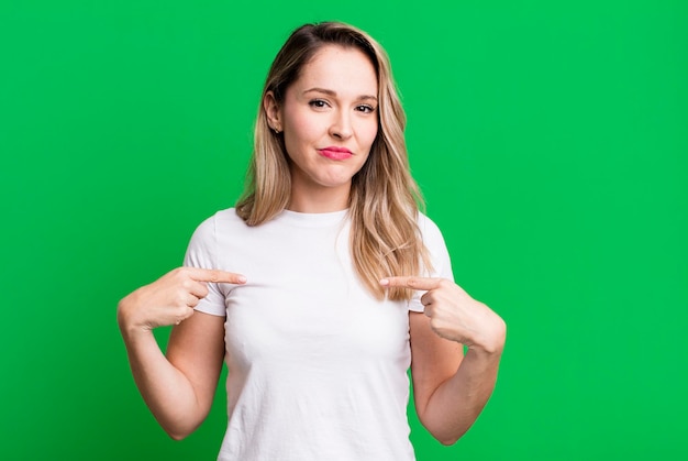 Looking proud positive and casual pointing to chest with both hands