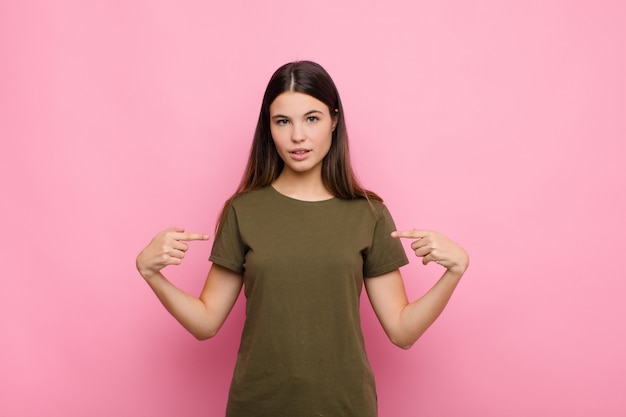 Photo looking proud, positive and casual pointing to chest with both hands