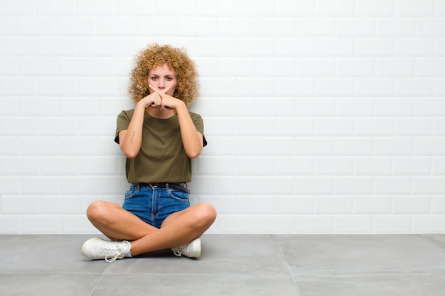 Foto sembrando serio e scontento di entrambe le dita incrociate davanti in segno di rifiuto, chiedendo silenzio