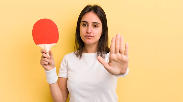 Looking serious showing open palm making stop gesture