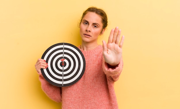 Looking serious showing open palm making stop gesture