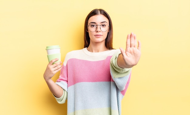 Looking serious showing open palm making stop gesture