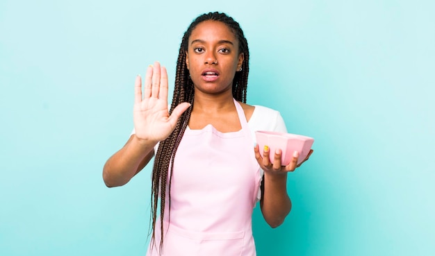 Looking serious showing open palm making stop gesture