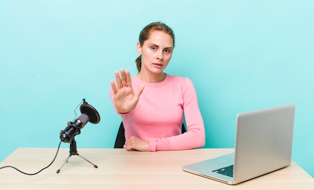 Looking serious showing open palm making stop gesture