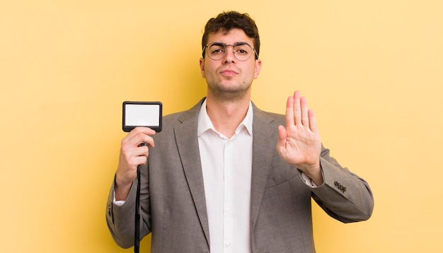 Looking serious showing open palm making stop gesture