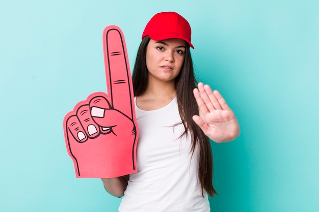 Looking serious showing open palm making stop gesture