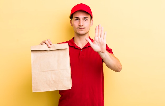 Looking serious showing open palm making stop gesture