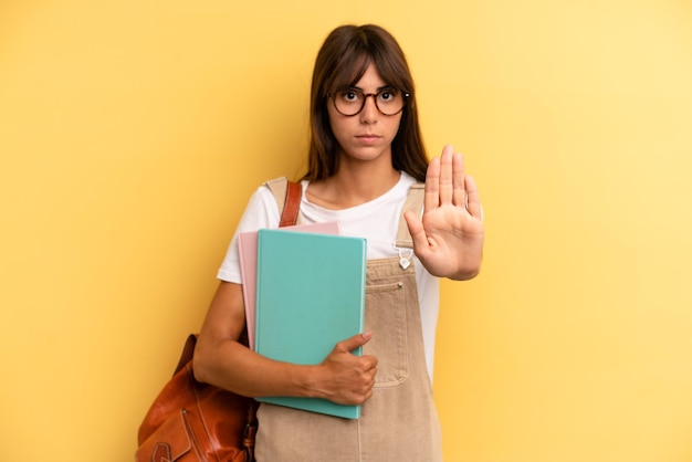 Looking serious showing open palm making stop gesture