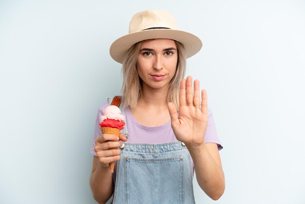 Looking serious showing open palm making stop gesture