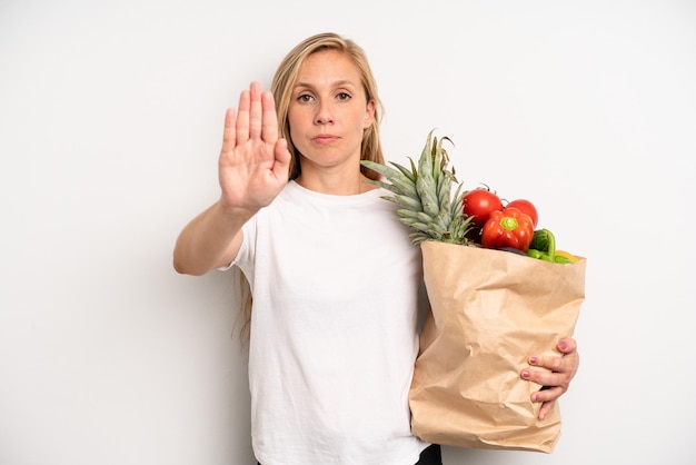 Looking serious showing open palm making stop gesture