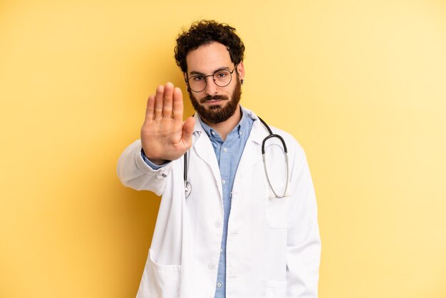 Looking serious showing open palm making stop gesture