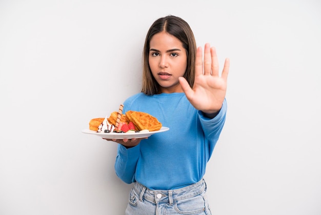 Photo looking serious showing open palm making stop gesture