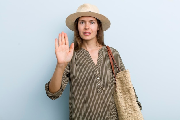 Looking serious showing open palm making stop gesture