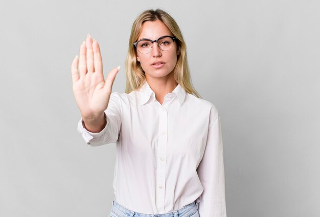 Looking serious showing open palm making stop gesture