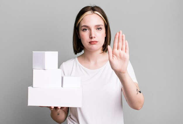 Looking serious showing open palm making stop gesture