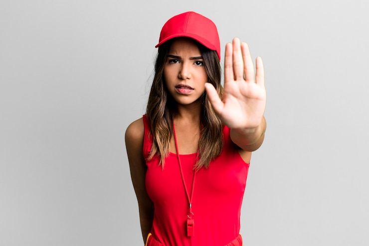 Photo looking serious showing open palm making stop gesture