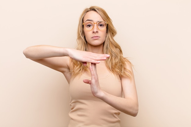 looking serious, stern, angry and displeased, making time out sign