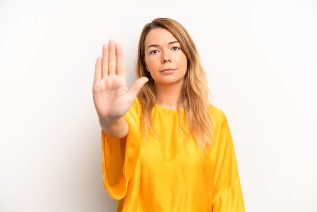 Looking serious stern displeased and angry showing open palm making stop gesture