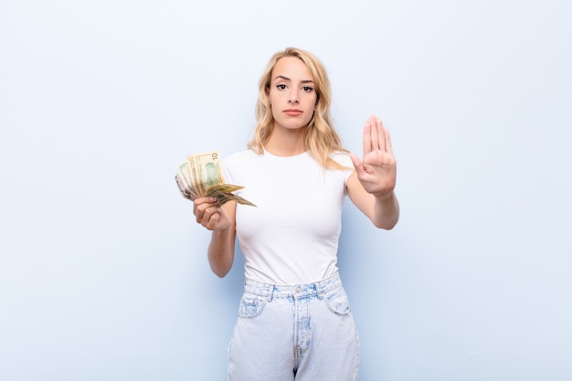 looking serious, stern, displeased and angry showing open palm making stop gesture