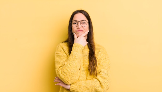 Looking serious thoughtful and distrustful with one arm crossed and hand on chin weighting options