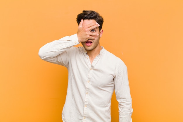 looking shocked, scared or terrified, covering face with hand and peeking between fingers