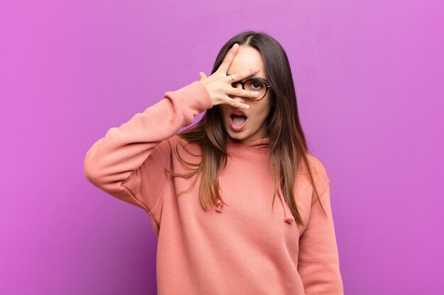 looking shocked, scared or terrified, covering face with hand and peeking between fingers