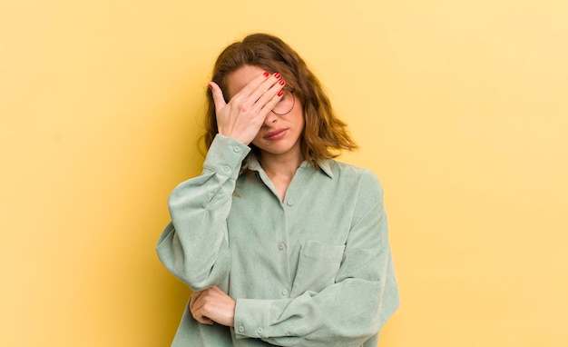 Photo looking stressed ashamed or upset with a headache covering face with hand