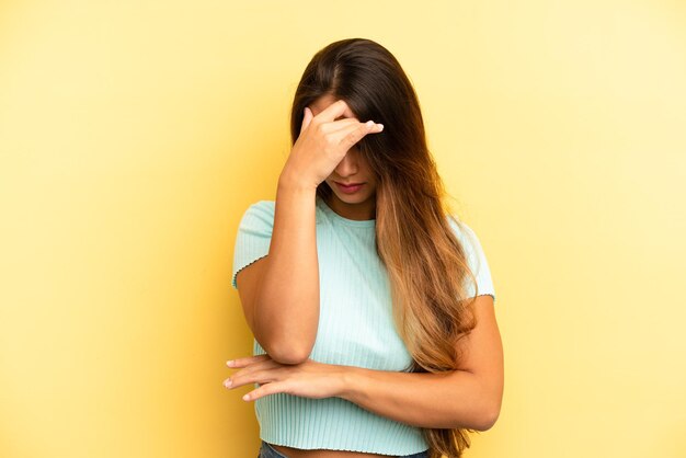 Guardando stressato vergognoso o sconvolto con un mal di testa che copre il viso con la mano