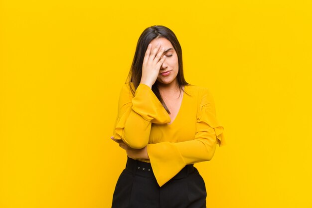 looking stressed, ashamed or upset, with a headache, covering face with hand