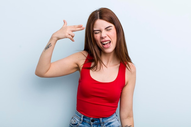 Looking unhappy and stressed suicide gesture making gun sign with hand pointing to head