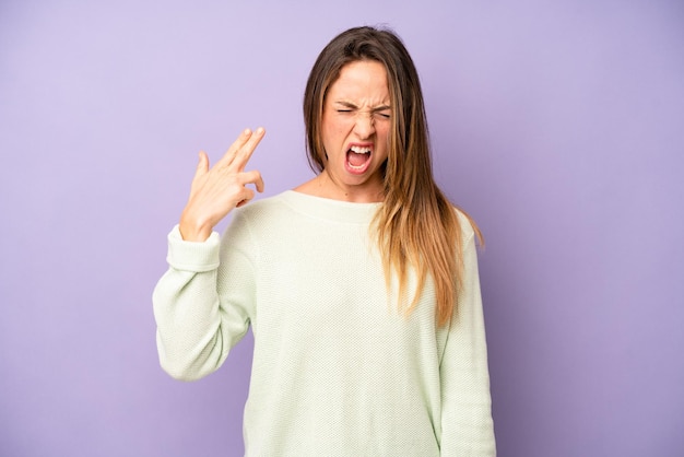 Looking unhappy and stressed suicide gesture making gun sign with hand pointing to head