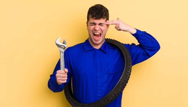 Looking unhappy and stressed suicide gesture making gun sign