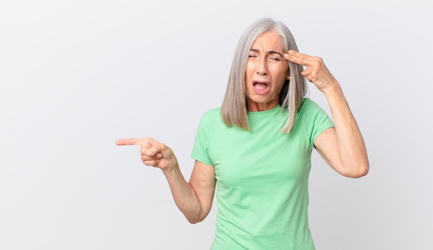 Looking unhappy and stressed suicide gesture making gun sign