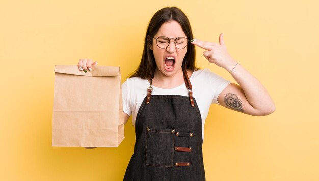 Looking unhappy and stressed suicide gesture making gun sign