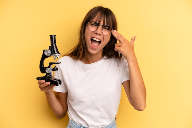 Looking unhappy and stressed suicide gesture making gun sign