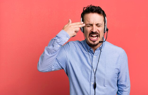 Looking unhappy and stressed suicide gesture making gun sign