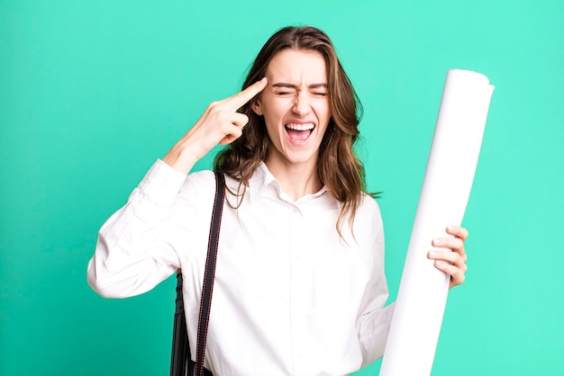 Looking unhappy and stressed suicide gesture making gun sign